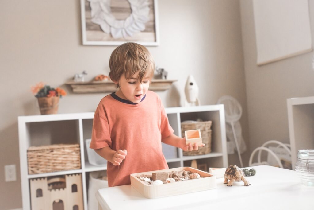 a boy in orange t-shirt is playing alone