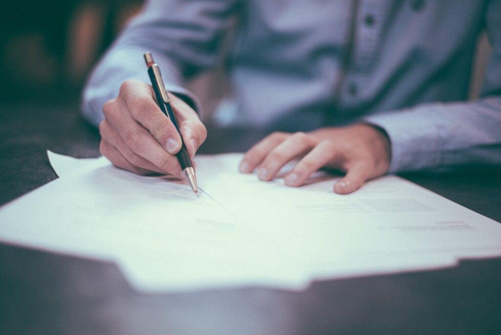 man writing some questions for his interview on paper