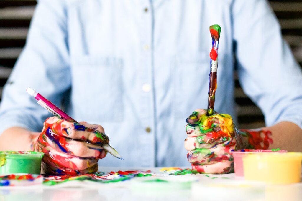 person holding click paint brushes