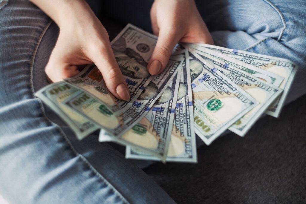 a person is holding $100 money in his hands do
