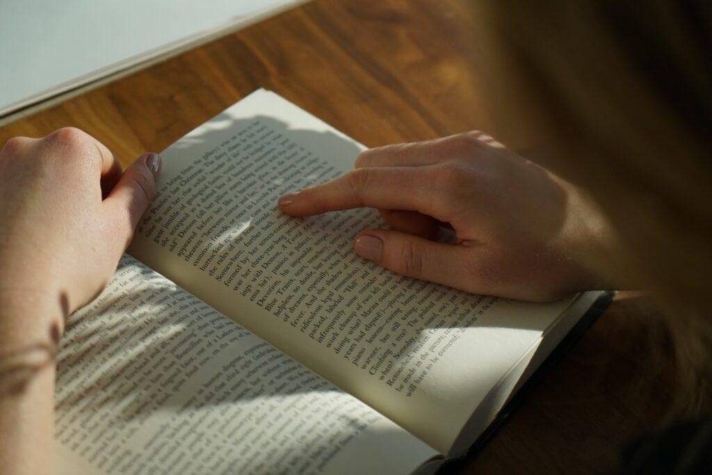 person reading book when he's feeling bored in class