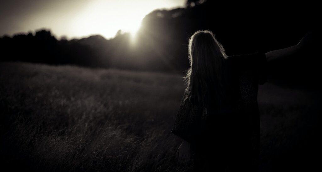 woman walking on grass field