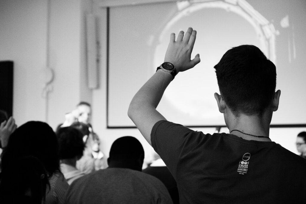 a male student is asking question in classroom