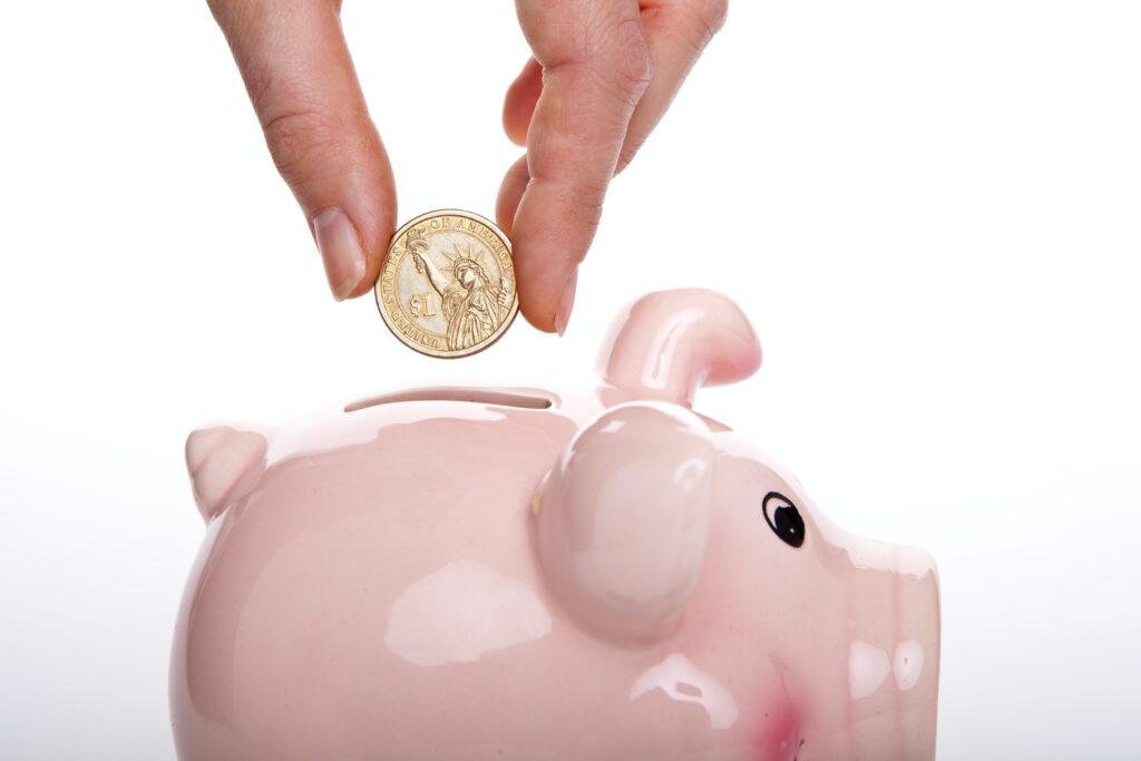 silver round coin on white ceramic pig coin bank