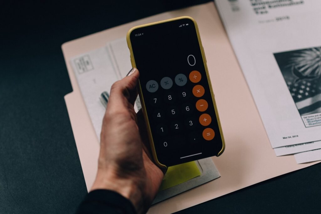 person making home budget on mobile calculator