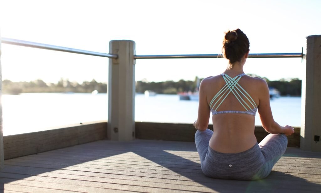 woman in gray skirt sitting on wooden dock during daytime