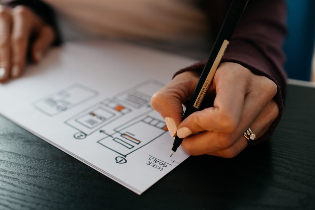 person writing his goals on white paper