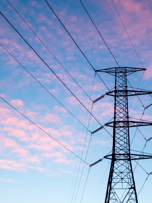 black electric pylon under orange clouds during daytime