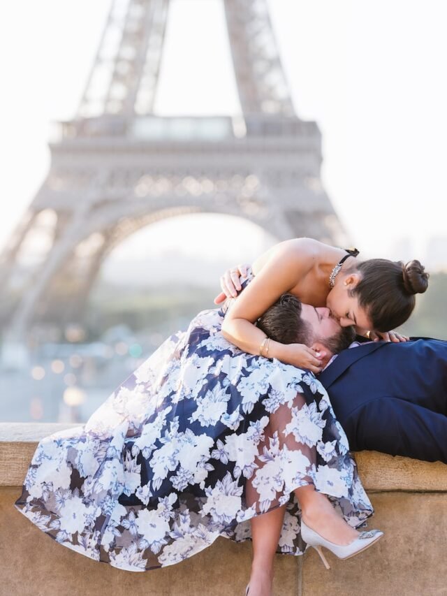 woman in white and black floral dress sitting on brown concrete bench during daytime
