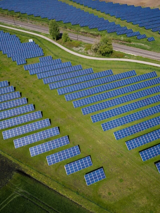 aerial photography of grass field with blue solar panels